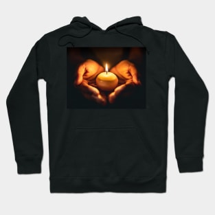 Small round candle burning held in hands Hoodie